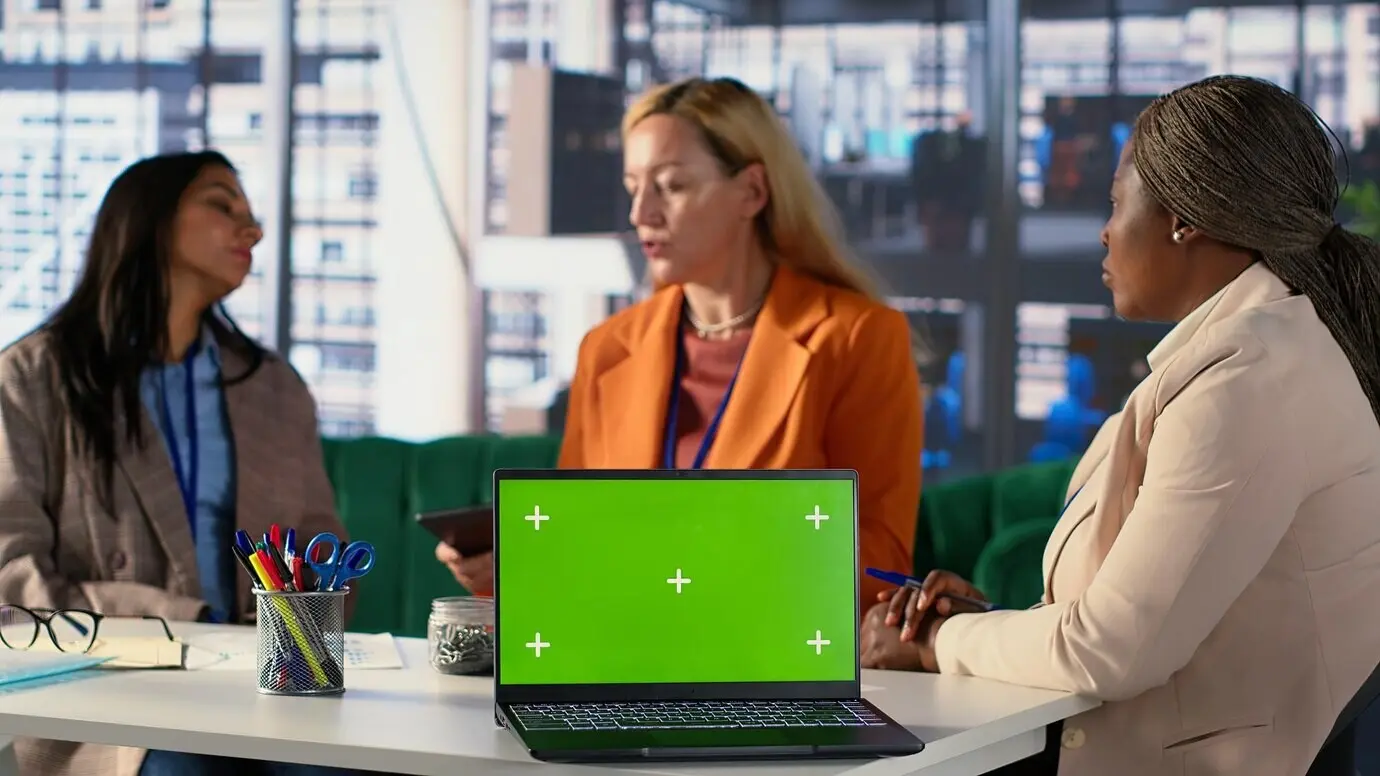 Multikulturelles Team von Spezialisten nutzt im Büro ein Mockup mit Platz für Text.